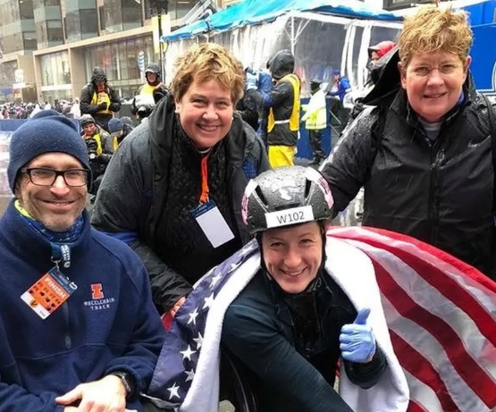 Report Co-Author Deborah McFadden and family with daughter, Tatyana McFadden, 20 time Paralympic medalist, at the finish line celebrating her first place finish in the Boston Marathon.